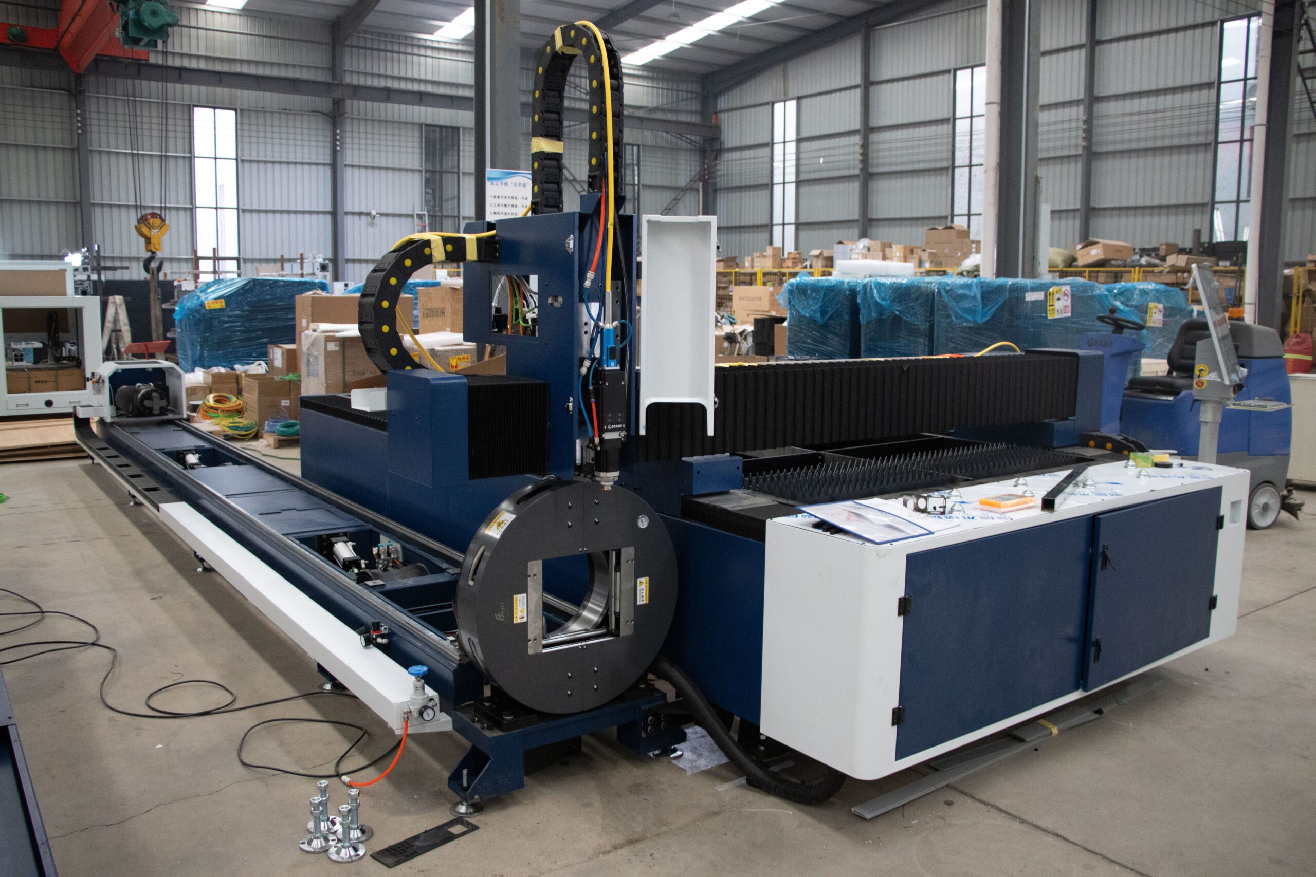 A large industrial laser cutter inside a warehouse in Jinan, China, showcasing advanced machinery.